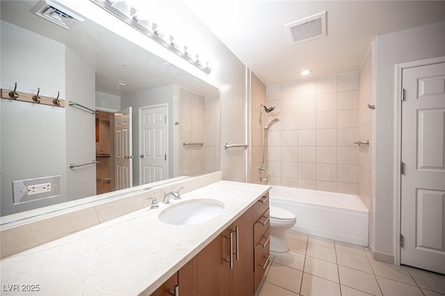 full bathroom with tile patterned floors, tiled shower / bath, vanity, and toilet