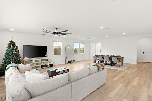 living room featuring ceiling fan and light hardwood / wood-style floors