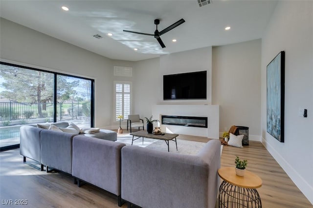 living room with light wood-type flooring and ceiling fan