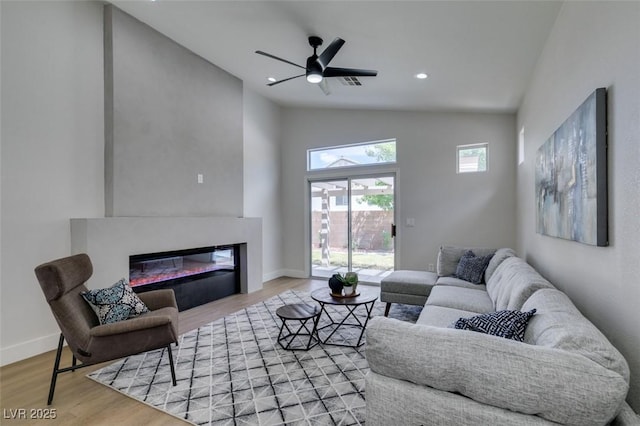 living room featuring hardwood / wood-style floors, ceiling fan, and high vaulted ceiling