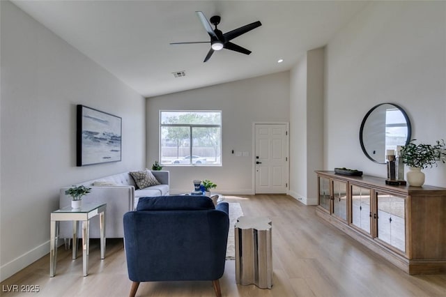 living room with ceiling fan, light hardwood / wood-style floors, and lofted ceiling