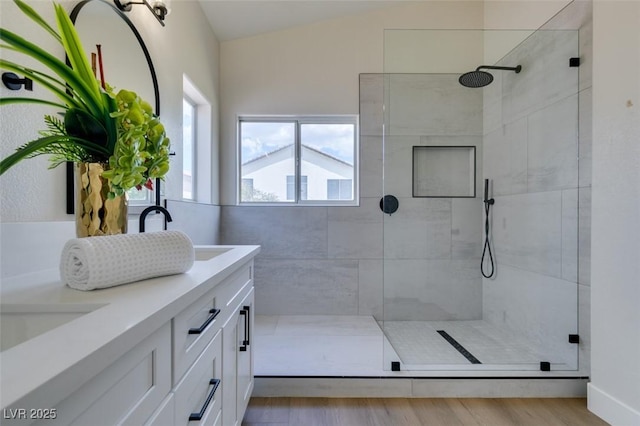 bathroom with wood-type flooring, a shower with door, and a wealth of natural light