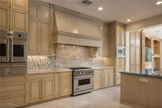 kitchen with appliances with stainless steel finishes, tasteful backsplash, light stone counters, and custom exhaust hood