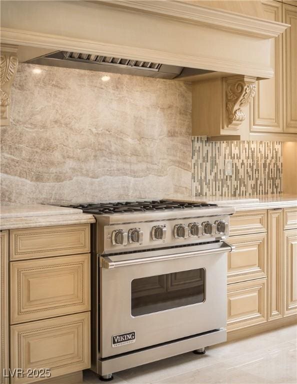 kitchen with high end range, premium range hood, and tasteful backsplash