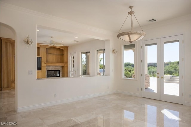 interior space with a fireplace, french doors, ceiling fan, and crown molding