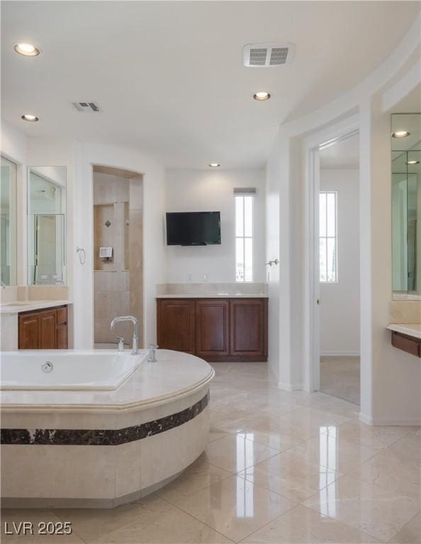 bathroom featuring vanity and independent shower and bath