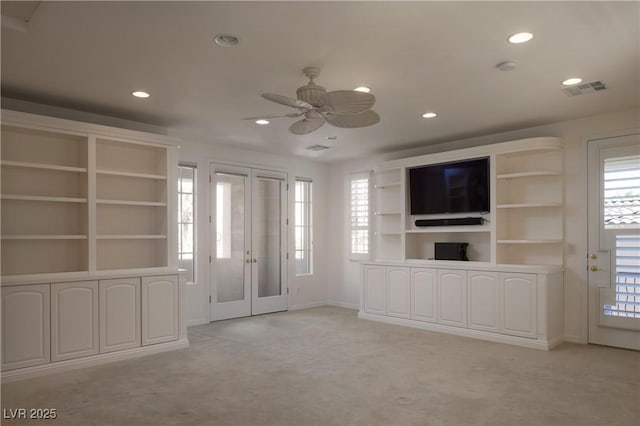 unfurnished living room featuring light carpet and ceiling fan