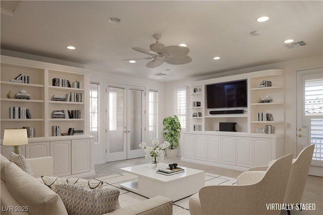 living room featuring french doors, ceiling fan, and built in shelves