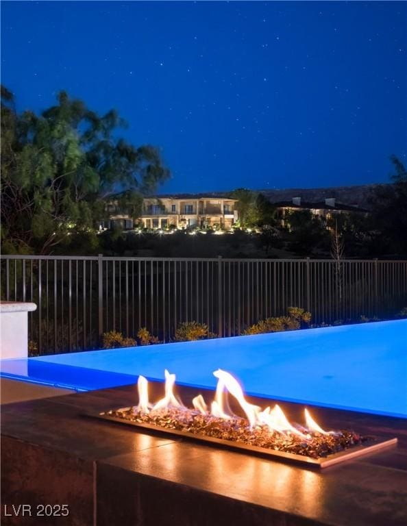 pool at twilight featuring a fire pit