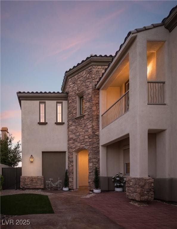 view of front of house featuring a balcony and a patio