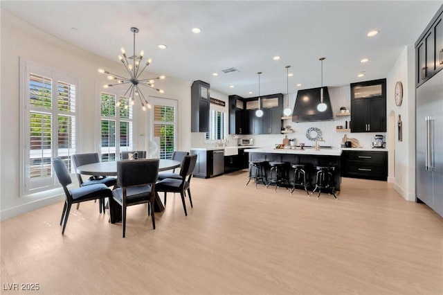 dining area with a notable chandelier and light hardwood / wood-style floors