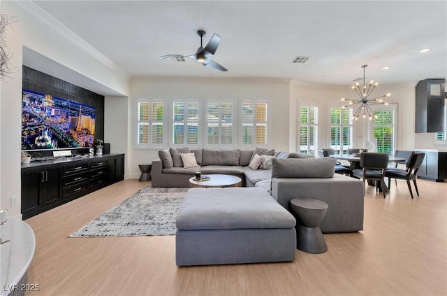 living room featuring ceiling fan with notable chandelier, light wood-type flooring, and ornamental molding