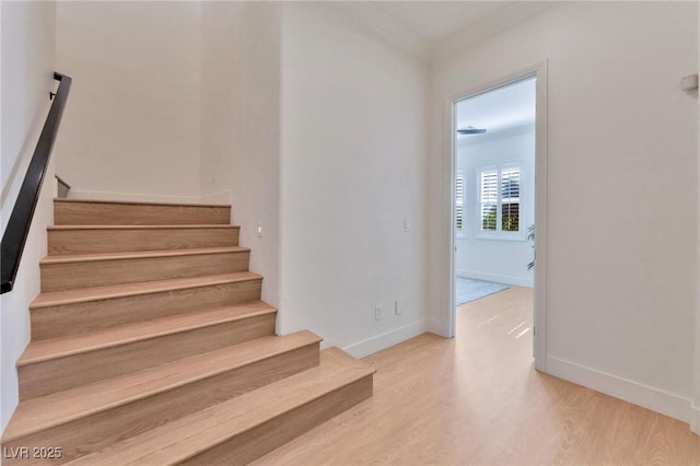 stairway featuring hardwood / wood-style floors and ornamental molding