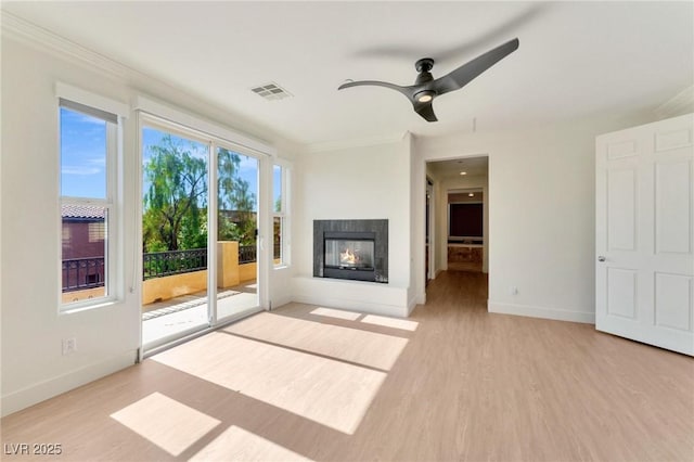 unfurnished living room with a multi sided fireplace, ceiling fan, crown molding, and light hardwood / wood-style floors