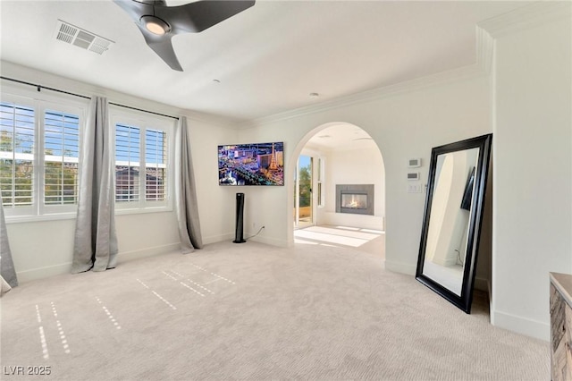 spare room with light carpet, ceiling fan, and ornamental molding