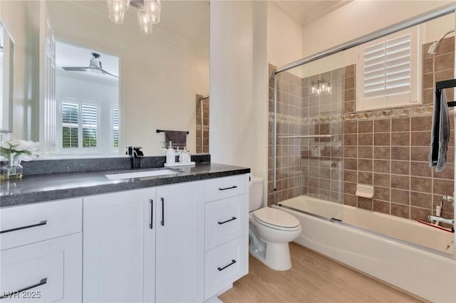 full bathroom featuring ceiling fan, enclosed tub / shower combo, wood-type flooring, toilet, and vanity