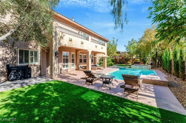 back of property with a lawn and a patio area