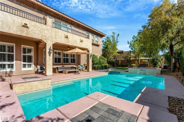 view of pool featuring an outdoor living space, a hot tub, and a patio area