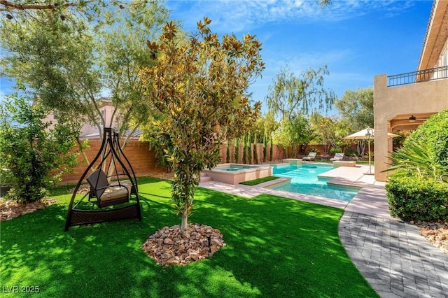 view of yard with a patio area, a balcony, and a pool with hot tub