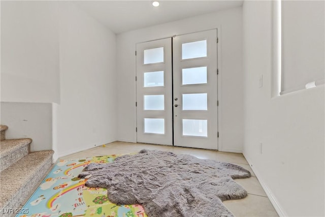 entryway featuring french doors, light tile patterned floors, and a healthy amount of sunlight