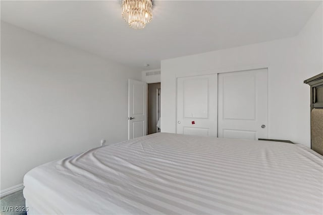 bedroom with carpet, a closet, and a notable chandelier