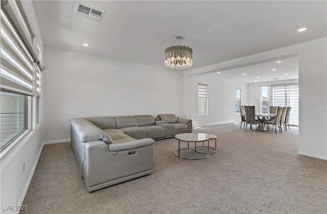 carpeted living room featuring a chandelier