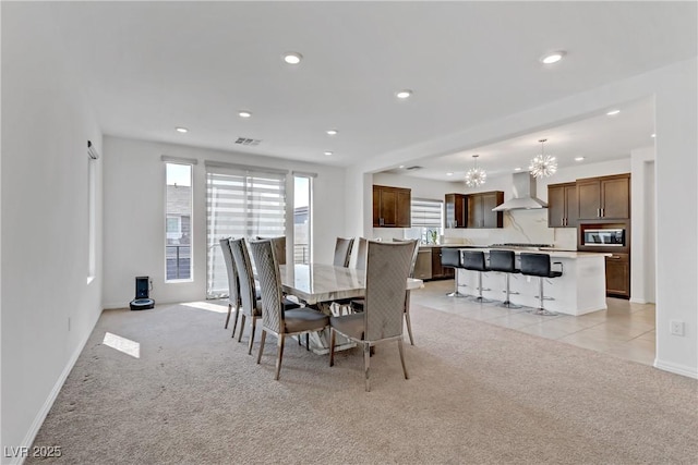 carpeted dining area with a chandelier