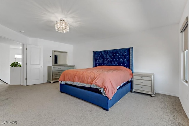 bedroom with light colored carpet and an inviting chandelier