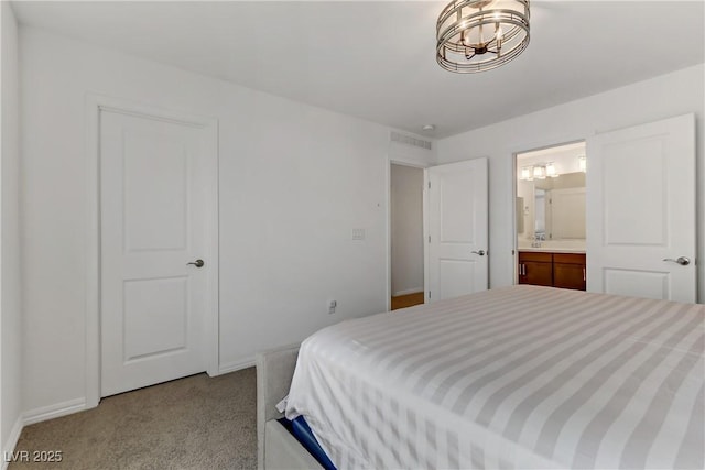 carpeted bedroom featuring ensuite bath