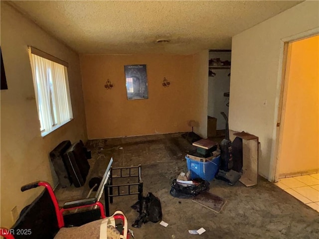 miscellaneous room with light tile patterned floors and a textured ceiling