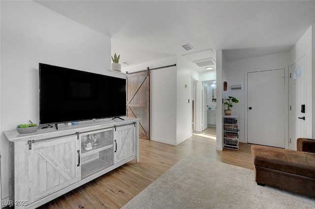 living room featuring a barn door and light wood-type flooring