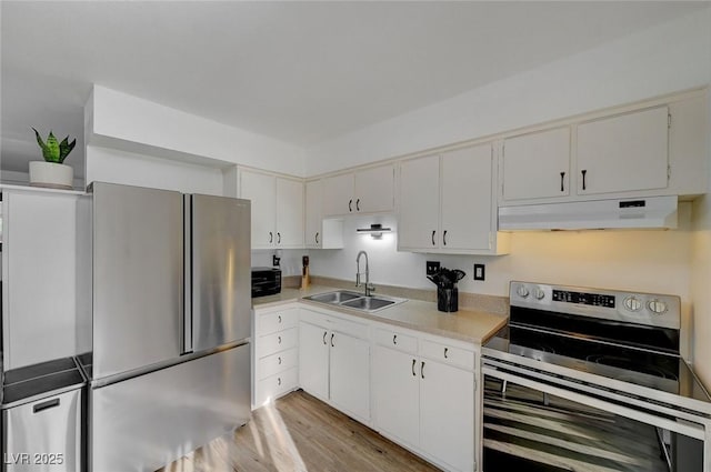 kitchen with white cabinetry, sink, stainless steel appliances, and light hardwood / wood-style floors