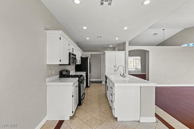 kitchen with white cabinetry, sink, tile countertops, light tile patterned floors, and appliances with stainless steel finishes