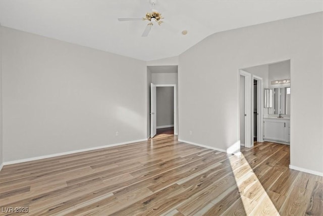 unfurnished bedroom featuring ensuite bathroom, ceiling fan, light hardwood / wood-style flooring, and vaulted ceiling