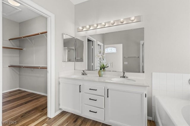 bathroom featuring a washtub, hardwood / wood-style floors, and vanity