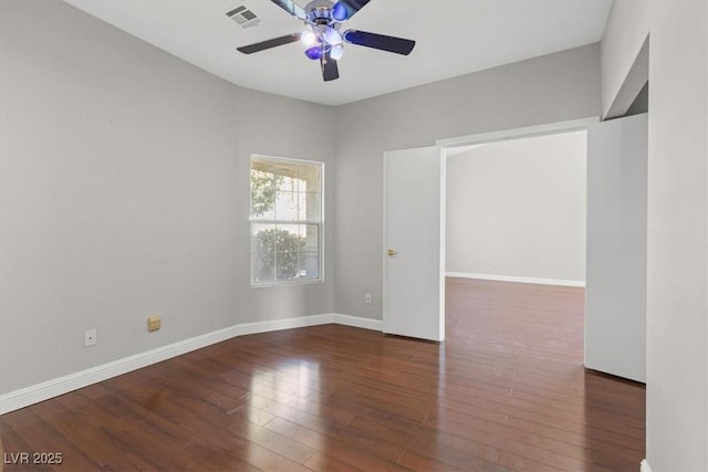 empty room with dark hardwood / wood-style floors and ceiling fan