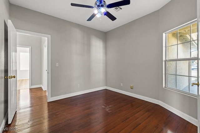 spare room featuring plenty of natural light, dark wood-type flooring, and ceiling fan