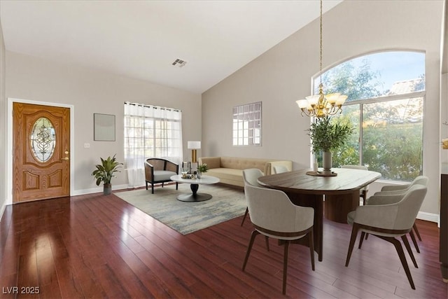 dining room with a notable chandelier, dark hardwood / wood-style flooring, and high vaulted ceiling