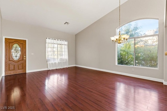 foyer with a chandelier, dark hardwood / wood-style flooring, and lofted ceiling