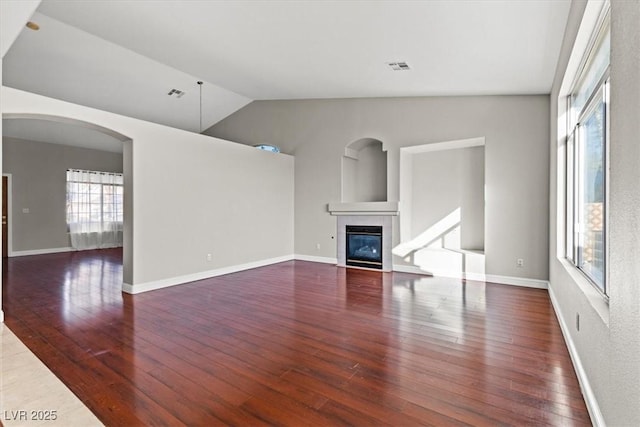 unfurnished living room featuring a fireplace, dark hardwood / wood-style floors, and lofted ceiling