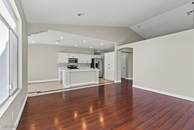 unfurnished living room with vaulted ceiling and hardwood / wood-style flooring