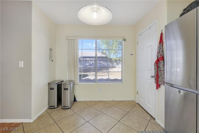 unfurnished dining area featuring light tile patterned flooring