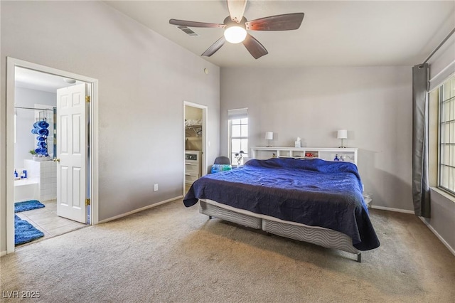 bedroom featuring a walk in closet, ceiling fan, ensuite bathroom, and light colored carpet