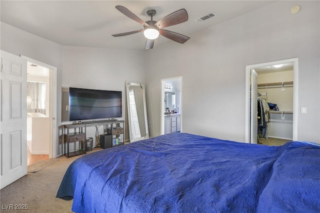 bedroom featuring connected bathroom, a spacious closet, ceiling fan, carpet floors, and a closet