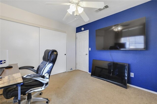 carpeted home office featuring ceiling fan