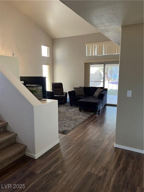 living room with a textured ceiling and dark wood-type flooring