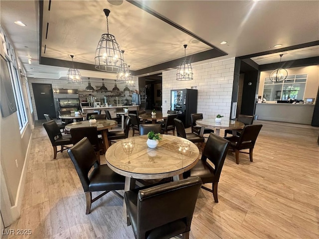 dining area featuring a raised ceiling and light wood-type flooring