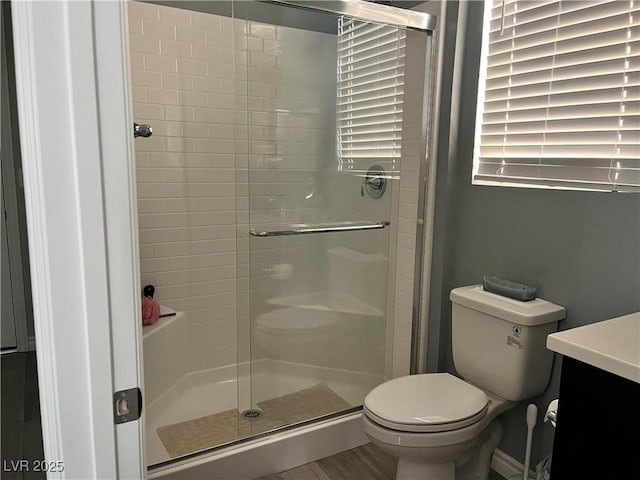 bathroom featuring vanity, toilet, and walk in shower