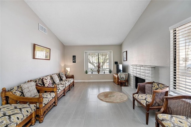 living room with vaulted ceiling and a brick fireplace