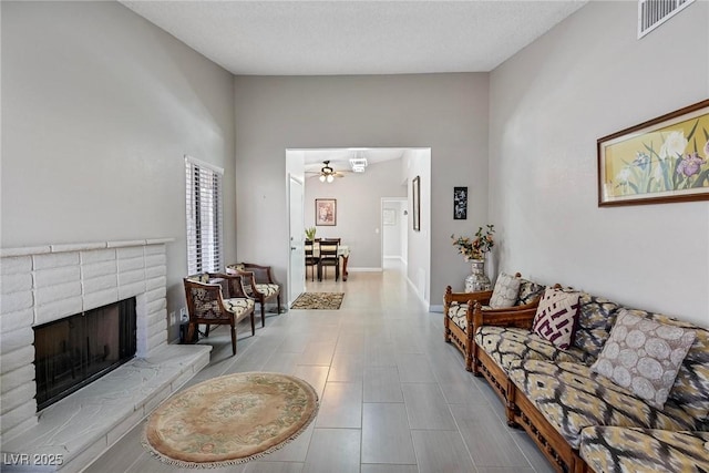 living room featuring ceiling fan and a fireplace